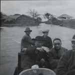Bishop Zhu Kaimin and a Chinese priest in a small motor boat