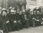 Foreign and Chinese priests seated next to the podium at the stadium of Aurora University