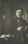 Fr. Vincent Lebbe wearing a cassock and holding a long pipe